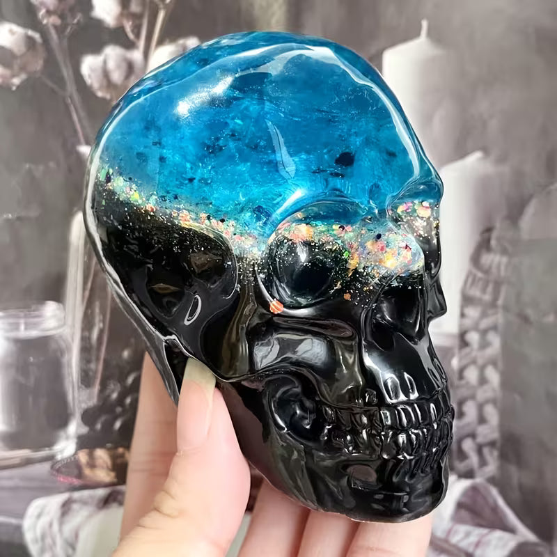 Black and blue resin skull held in hand, made with the medium skull mould
